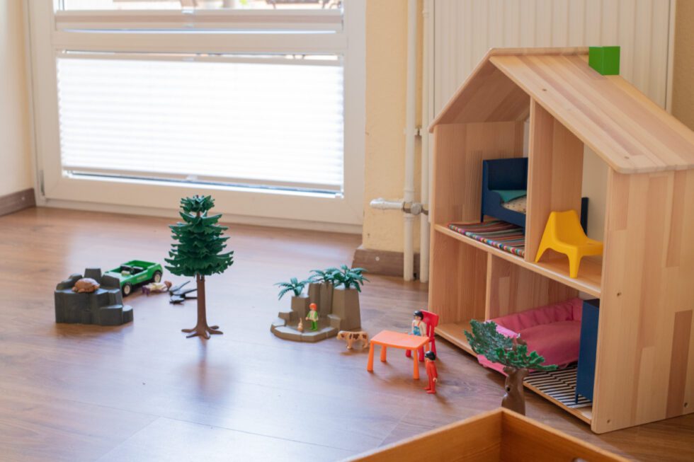 Ein Spielbereich für Kinder mit Puppenhaus und Playmobil.